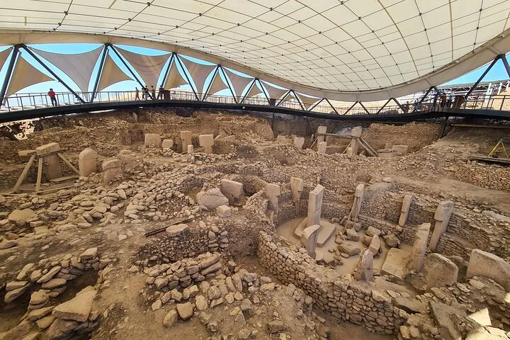 The dig and its stone circles under the curved protective roof on a Gobekli Tepe tour of two days from Istanbul, Turkey